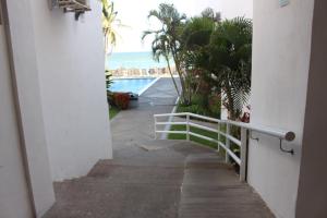 una scala che conduce a un balcone con vista sull'oceano di Hotel y Suites Corita a Bucerías