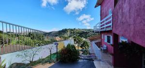a balcony of a pink building with a view at Betume in Campos do Jordão