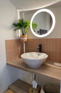 a bathroom with a white sink and a mirror at Hôtel PALMITO in Biarritz