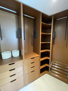 a walk in closet with wooden cabinets and shelves at Hôtel PALMITO in Biarritz