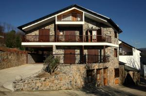 Casa de piedra con balcón en la parte superior. en Hotel Rural Casa Ana en Vega de Espinareda