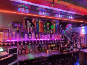 a bar with a bunch of bottles and neon lights at Mardi Gras Hotel in Blackpool