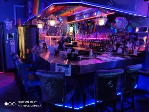 un bar en un restaurante con luces moradas en Mardi Gras Hotel, en Blackpool