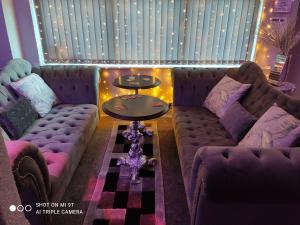 a living room with a couch and a table at Mardi Gras Hotel in Blackpool