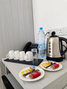 a table with two plates of food and a coffee maker at La Veranda Hotel in Larnaca