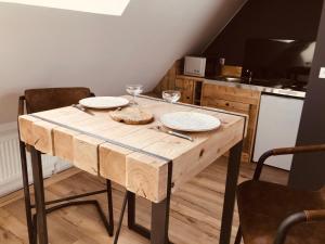 uma mesa de madeira com dois pratos numa cozinha em Studio Escapade Normande proche Etretat em Saint-Jouin-Bruneval