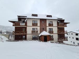 a large building with snow on it in the snow at VILA KRUNA Apartments in Kopaonik