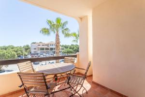 balcón con mesa, sillas y vistas al agua en Appartement Orihuela Costa Golf, Las Ramblas, en Villacosta