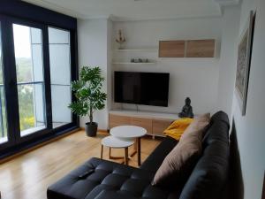 a living room with a couch and a tv at Olas Deluxe Salinas in Salinas