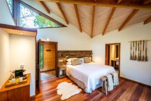 a bedroom with a bed and a large window at Rakau Lodge in Pucón