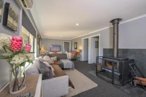 sala de estar con sofá y chimenea en East Jindabyne- Cavallino 4 bedroom home en Jindabyne