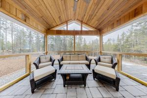 a screened in porch with chairs and a table at Creek Cottage in Bass Harbor