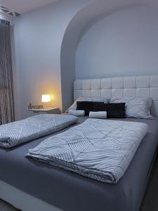 una camera con 2 letti e una testiera bianca di Apartment Carpe Diem a Capodistria