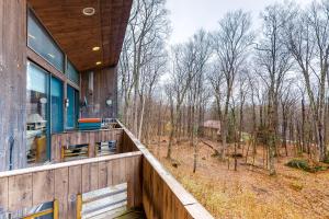a house with a balcony with a view of the woods at Delightful Seclusion in Stratton