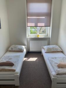 due letti in una piccola stanza con una finestra di Apartmány U Muzea a Děčín