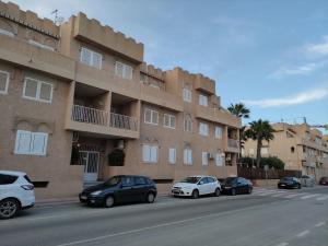 um grupo de carros estacionados em frente a um edifício em Apartamento Bolnuevo (Mazarrón) em Bolnuevo