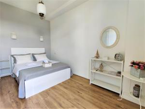 - une chambre blanche avec un lit et un miroir dans l'établissement Avlabari Apartment, à Tbilissi
