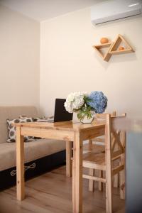 a wooden desk with a laptop and flowers on it at Cottages in Kaprovani "Family nest" in Ureki