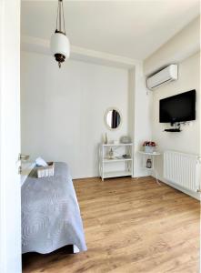 een witte kamer met een bed en een televisie bij Avlabari Apartment in Tbilisi City