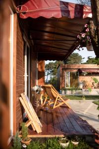 2 chaises assises sur une terrasse couverte avec un parasol dans l'établissement Cottages in Kaprovani "Family nest", à Ureki