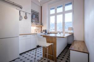 una cucina con armadi bianchi e piano di lavoro di Boutique Charme Apartment Ricarda a Baden-Baden