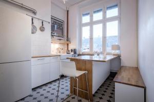 eine Küche mit weißen Schränken und einer Arbeitsplatte in der Unterkunft Boutique Charme Apartment Ricarda in Baden-Baden