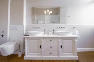 a white bathroom with two sinks and a toilet at Boutique Charme Apartment Ricarda in Baden-Baden +28 photos