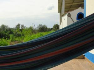 a hammock on the side of a house at Vale do Boto-Quinta com 3 casas in Castro Marim