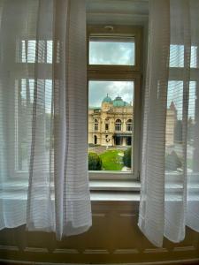 una ventana con cortinas blancas frente a un edificio en SKY HOSTEL en Cracovia