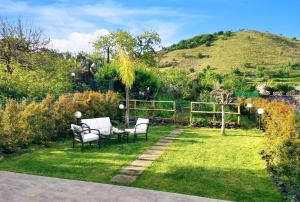 um jardim com duas cadeiras e uma mesa na relva em La Sciara Etna Home em Linguaglossa