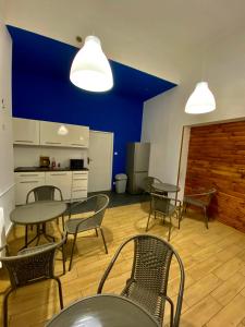 a room with tables and chairs and a blue wall at SKY HOSTEL in Krakow