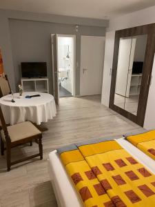 een kamer met een bed, een tafel en een spiegel bij Hotel Slavia in Betzdorf