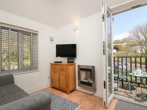 a living room with a fireplace and a tv at Tater-du in Porthcurno