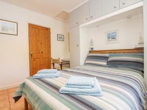 a bedroom with a bed with towels on it at Tater-du in Porthcurno