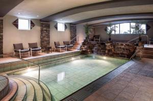 a lap pool in a hotel with chairs and tables at Royal Canadian Lodge in Banff