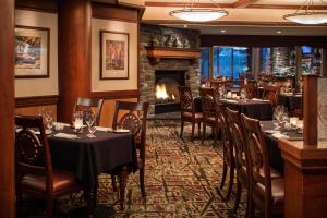 a restaurant with tables and chairs and a fireplace at Royal Canadian Lodge in Banff