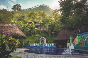 a resort with a swimming pool in front of a mountain at Viñas Hotel in Lanquín