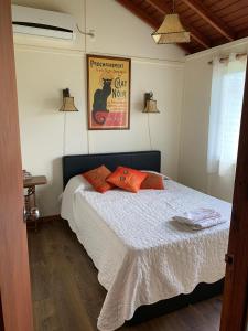 ein Schlafzimmer mit einem Bett mit orangefarbenen Kissen darauf in der Unterkunft Cabaña Punta Negra in Punta Colorada