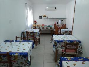 una sala da pranzo con due tavoli e sedie e una sala con tavolo di Pousada Genial a Gramado