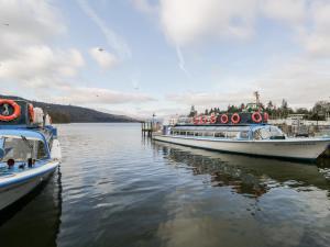 two boats are docked at a dock on the water at Tree Tops View in Windermere