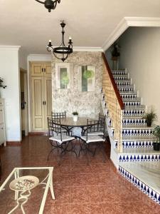 sala de estar con escalera, mesa y sillas en Airam house, en Mazagón
