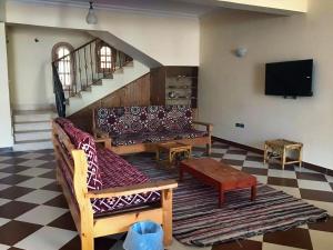 sala de estar con sofás y TV de pantalla plana. en Dahab Vibes Villas en Dahab