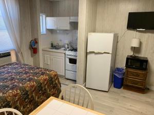 eine Küche mit einem Kühlschrank und einem Tisch im Zimmer in der Unterkunft Oakview Hotel in Wildwood