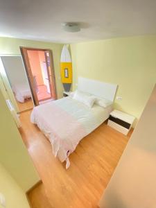 1 dormitorio con 1 cama grande y espejo en S&H La Marimorena, en Ribadeo