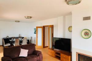 a living room with a couch and a flat screen tv at Aparatmento T3 com vista mar em condomínio de Luxo in São Martinho do Porto