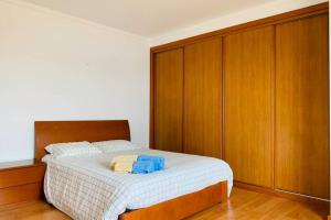 a bedroom with a bed with a wooden cabinet at Aparatmento T3 com vista mar em condomínio de Luxo in São Martinho do Porto +21 photos