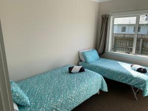 1 dormitorio con 2 camas y ventana en Brixton farm stay, en Waitara