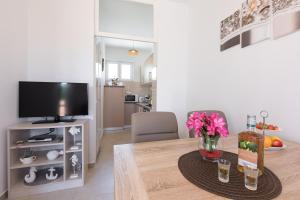 a living room with a dining room table with a television at Apartment Oleander in Punat