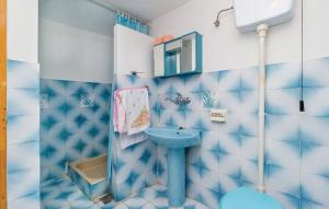 ein blau-weißes Badezimmer mit Waschbecken und Toilette in der Unterkunft Apartments Vukelic in Senj