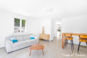 un soggiorno con divano bianco e tavolo di Gorgeous 3 bedroom house with AC and garden - Dodo et Tartine a Le Revest-le-Eaux